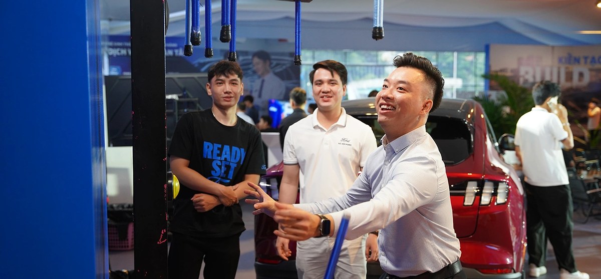 Khách tham dự thử tài phản xạ với trò chơi bắt gậy tại khu trải nghiệm trong showroom Ford